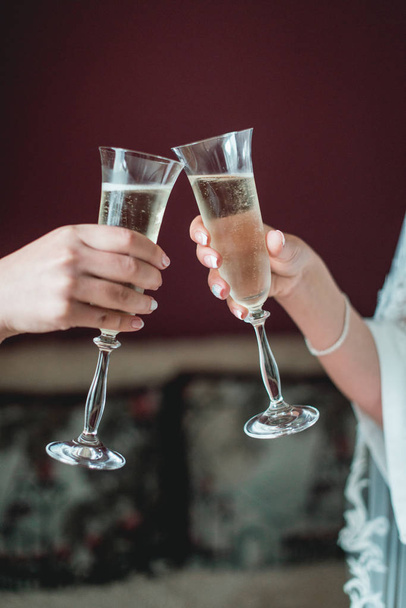 Meisjes houden in handen glazen met witte wijn. huwelijksfeest. - Foto, afbeelding