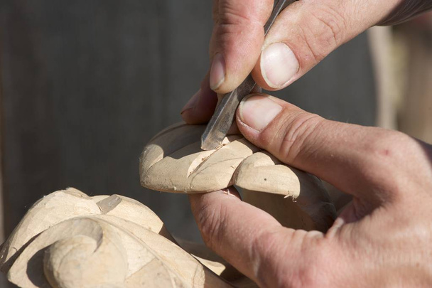 Woodcarving process. A closeup shot of a male hands, tools and the wooden piece. - 写真・画像