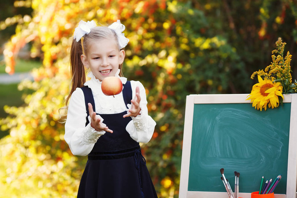 Schoolgirl with a chalkboard in the park. - Photo, Image