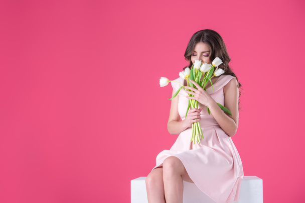 attractive girl sniffing bouquet of tulips isolated on pink - Fotoğraf, Görsel