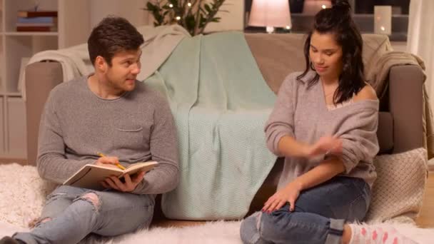 man with sketchbook drawing his girlfriend at home - Imágenes, Vídeo
