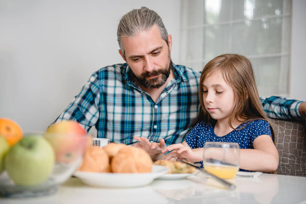 Father and daughter using tablet during breakfast - Φωτογραφία, εικόνα