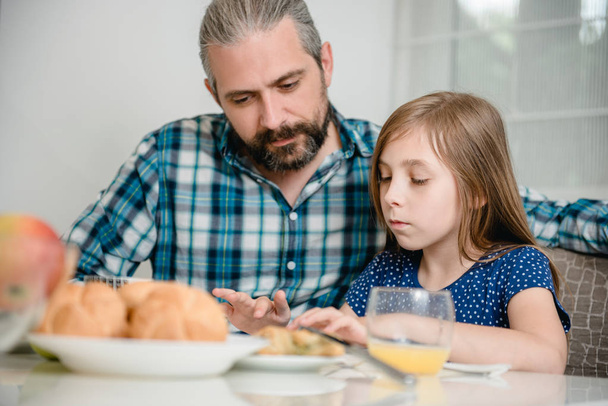 Father and daughter using tablet during breakfast - Foto, Bild