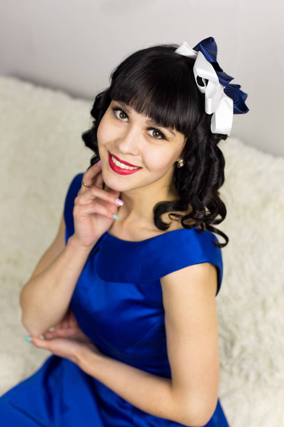 Girl brunette in a blue dress on a white background. - Valokuva, kuva