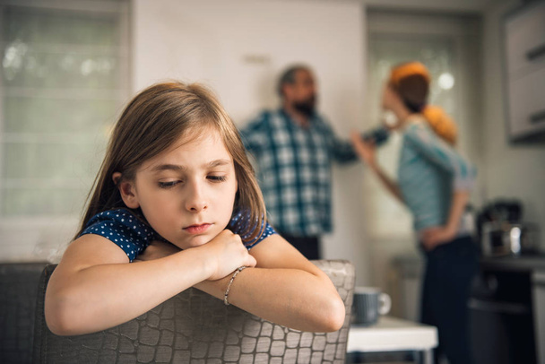 Hija traumatizada escuchando a padres discutiendo en casa
 - Foto, Imagen