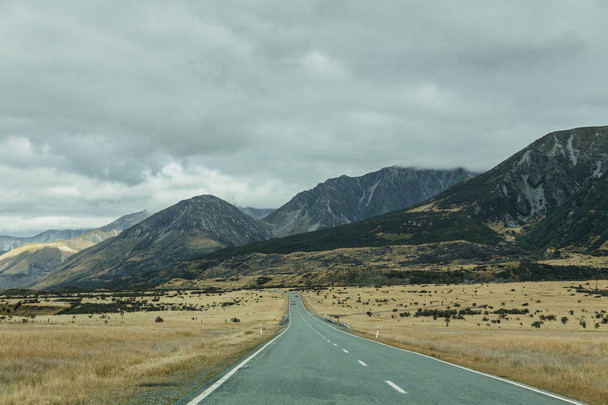 Mountain landscape with road and blue sky, Otago, New Zealand - Φωτογραφία, εικόνα