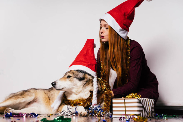 woman in a New Year hat sits next to a dog - Fotó, kép