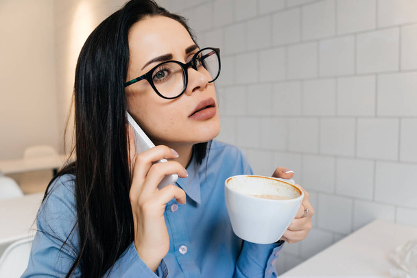 woman drinking coffee and talking on the phone - Foto, immagini