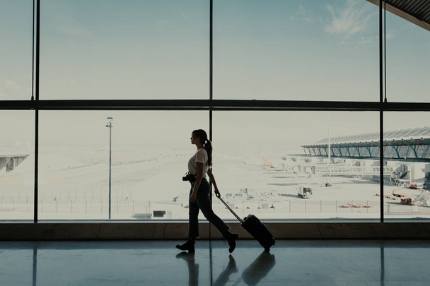Žena na letišti chodí s kufrem - Fotografie, Obrázek