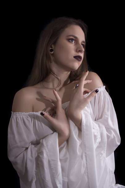 Young woman with white dress posing on black background - Foto, immagini