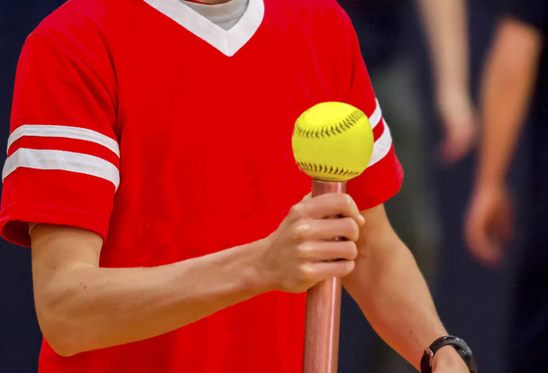 Equilibrar una pelota de softbol sobre una batuta
 - Foto, Imagen