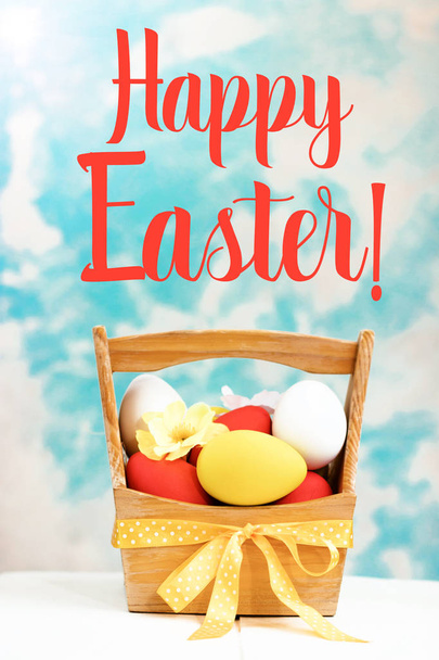 Easter spring composition, basket with painted colorful eggs. Close up portrait on sky background. - Fotó, kép