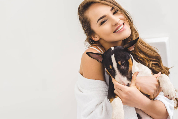 portrait of cheerful young woman with dog - Фото, изображение