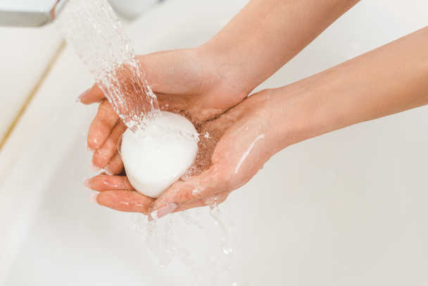 自宅で石鹸で手を洗う女性の部分的なビュー - 写真・画像
