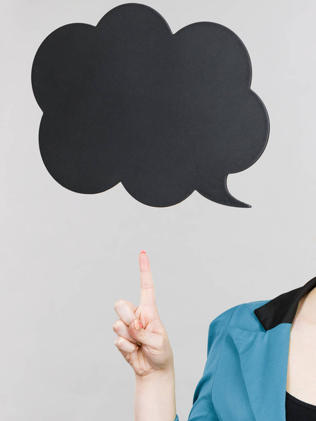 Woman hand pointing at black thinking speech bubble - Foto, afbeelding