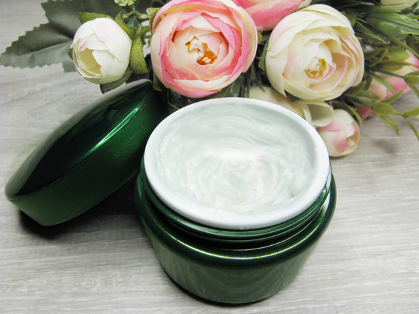 crème cosmétique pour soins du visage et fleurs roses
  - Photo, image