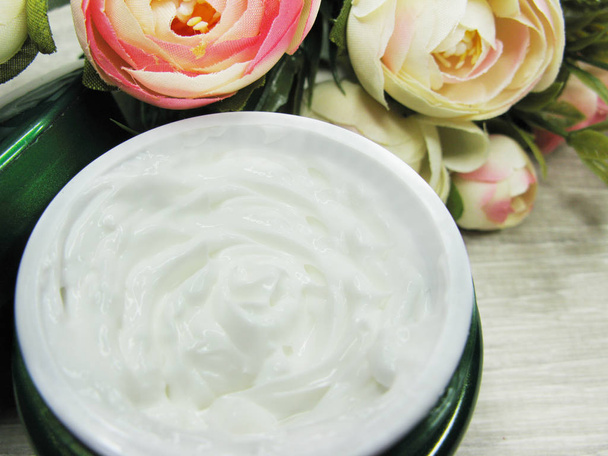 crema cosmética para el cuidado de la cara y flores de rosas
  - Foto, Imagen