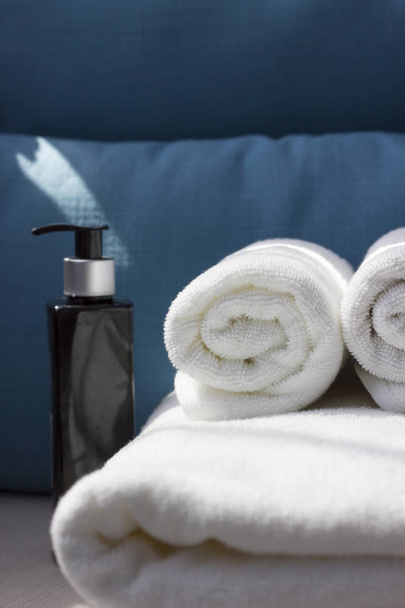 White cotton towel on a blue background. A piece of beauty salon or bathroom interior. Copy space  - Φωτογραφία, εικόνα