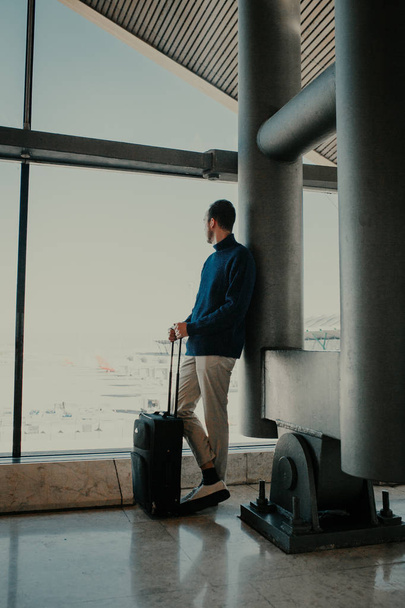 Ember a bőröndöt, a háttérben a repülőtéren - Fotó, kép