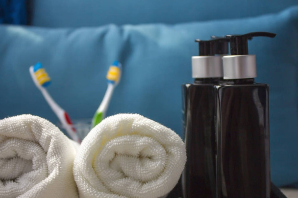 Witte katoenen handdoek met cosmetische producten. Een stukje schoonheidssalon of badkamer interieur. Kopieer ruimte. Close-up  - Foto, afbeelding