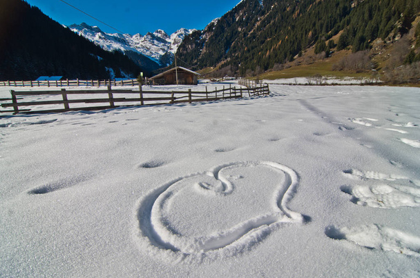 背景の山と雪の中でエッチングの心 - 写真・画像