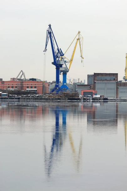 Jeřábů přístavu na břehu s odraz ve vodě - Fotografie, Obrázek