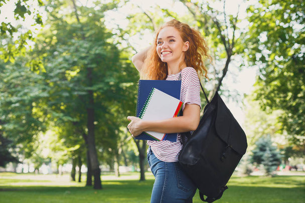 Молодая рыжая студентка прогуливается по парку
 - Фото, изображение