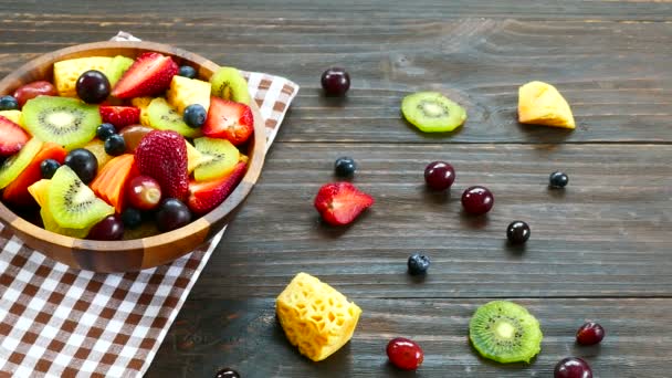 assorted ripe fruits and berries in wooden bowl on rustic table  - Footage, Video