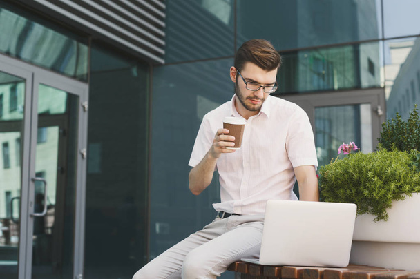 Jeune homme d'affaires travaillant avec ordinateur portable à l'extérieur
 - Photo, image