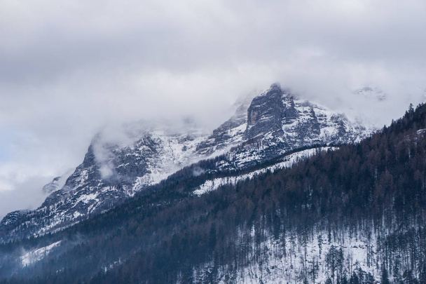 Bulutlar piercing dramatik karla kaplı tepeler ile epik dağ sahne - Fotoğraf, Görsel