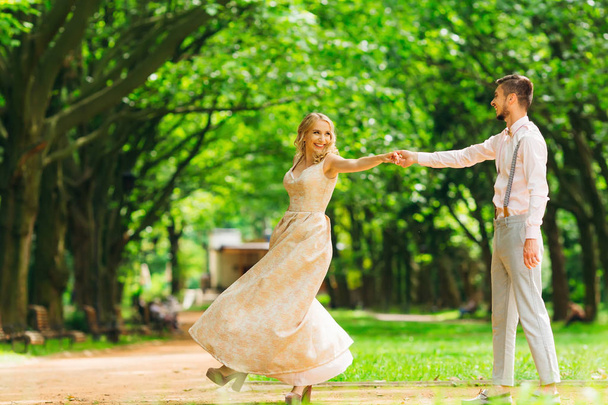 Un par de ropa elegante bailando en un parque en el fondo de
 - Foto, Imagen