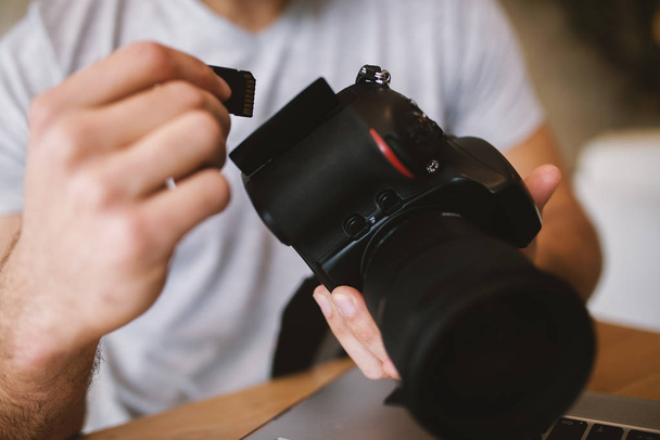 руки человека, вынимающего SD-карту из профессиональной камеры
 - Фото, изображение