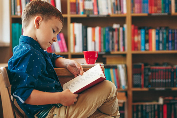 Ανάγνωση αγόρι με φλυτζάνι του τσαγιού - Φωτογραφία, εικόνα