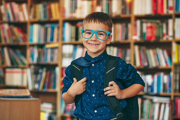 Boy with backpack in library - Foto, Imagem
