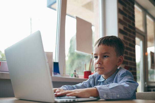 хлопчик друкує на ноутбуці
 - Фото, зображення