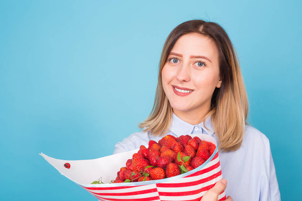 Close up of young woman with a bouquet of strawberry - Foto, Imagem