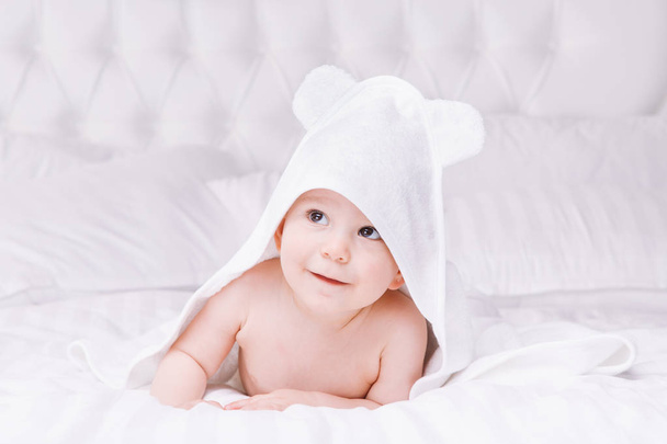 Adorablement bébé allongé sur une serviette blanche dans le lit. Bonne enfance et concept de soins de santé
. - Photo, image
