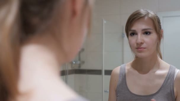 Joven mujer poniendo lápiz labial en los labios, espejo
 - Metraje, vídeo