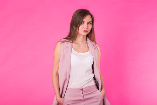 Современная бизнес-леди на космическом розовом фоне, женщина, уверенно позирующая. Концепция повседневной одежды
 - Фото, изображение