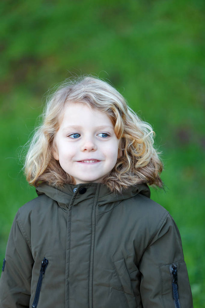 портрет счастливого маленького ребенка в пальто на открытом воздухе
 - Фото, изображение