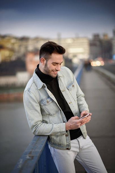Young handsome man using his cell phone, enjoying a day on the street - Foto, Bild