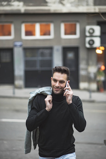 Young handsome man using his cell phone, enjoying a day on the street - Foto, Bild