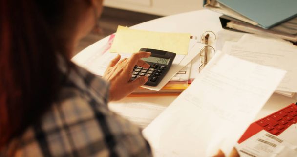 Mujer mayor usando calculadora para impuestos y presupuesto en casa
 - Foto, imagen