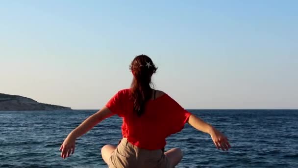 Γυναίκα διαλογισμό, κάνουμε γιόγκα θέτουν κατά το ηλιοβασίλεμα στην παραλία - Πλάνα, βίντεο