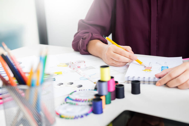 jonge vrouwen werken als modeontwerper tekenen schetsen voor clo - Foto, afbeelding