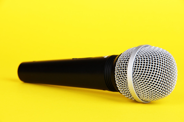 Black microphone on yellow background - Foto, Imagem