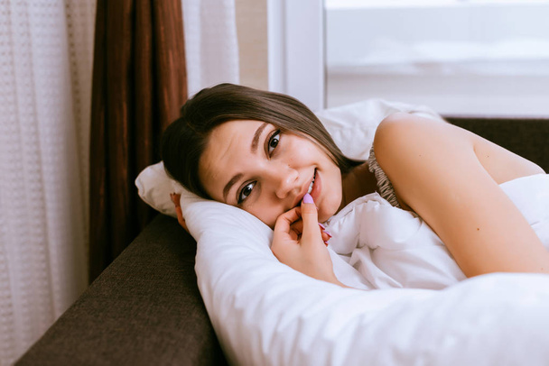 cute smiling girl lies in bed, early in the morning - Zdjęcie, obraz