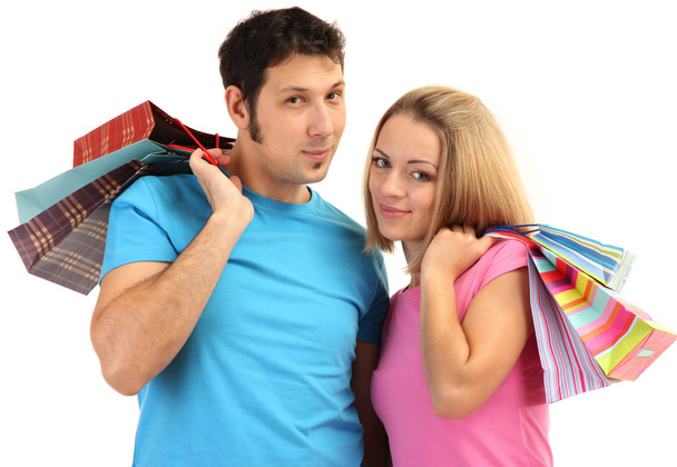 Young couple shopping and holding many shopping bags isolated on white - Фото, зображення