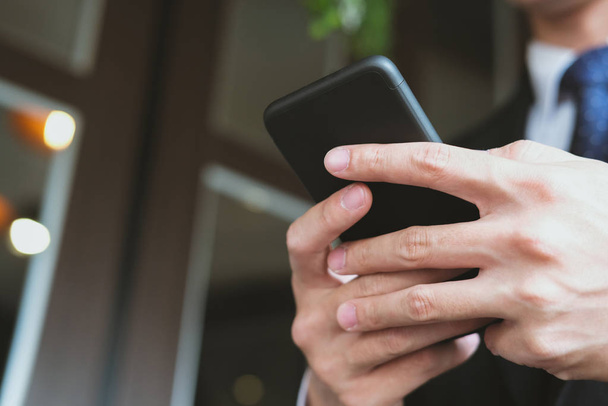 businessman holding smartphone & using app. man texting message  - Фото, зображення