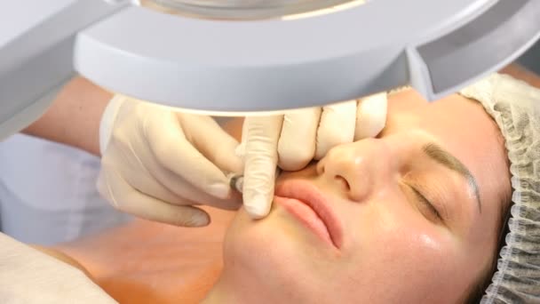 Conceito de clínica de beleza. Close-up de mãos esteticistas fazendo injeção de botox nos lábios femininos. A jovem tem um procedimento de injecção facial. Rejuvenescimento facial. 4k
 - Filmagem, Vídeo